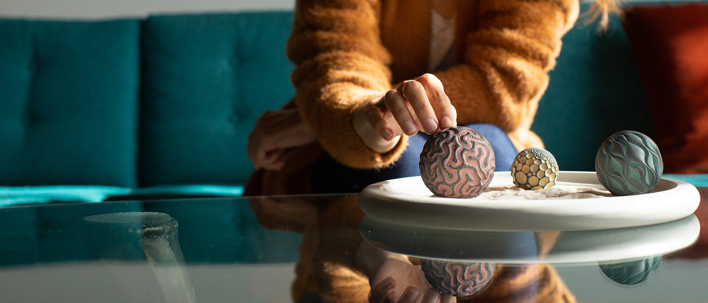 Woman Meditating Using Kinetic Ceramic Balls and Sand