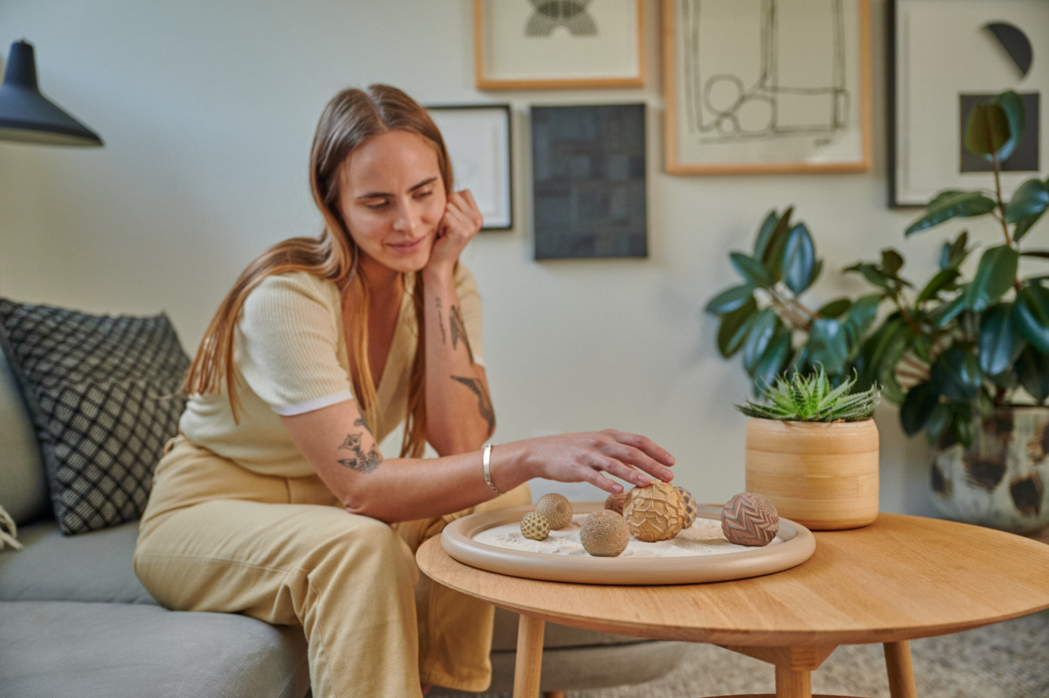 Woman Sitting Calmly Using Zen Sand Garden